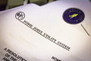 A close-up view of Nome Joint Utility System documents and letterhead.