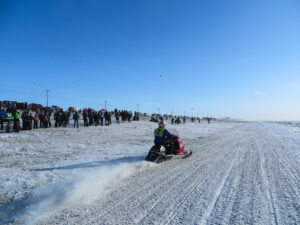 Quinn Schaeffer (Bib #2) speeds down East Beach to start the 2016 Nome-Golovin snowmachine race. Photo: Laura Kraegel, KNOM.