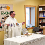 On dedication day, Father Ross Tozzi celebrates Mass in KNOM’s lobby.