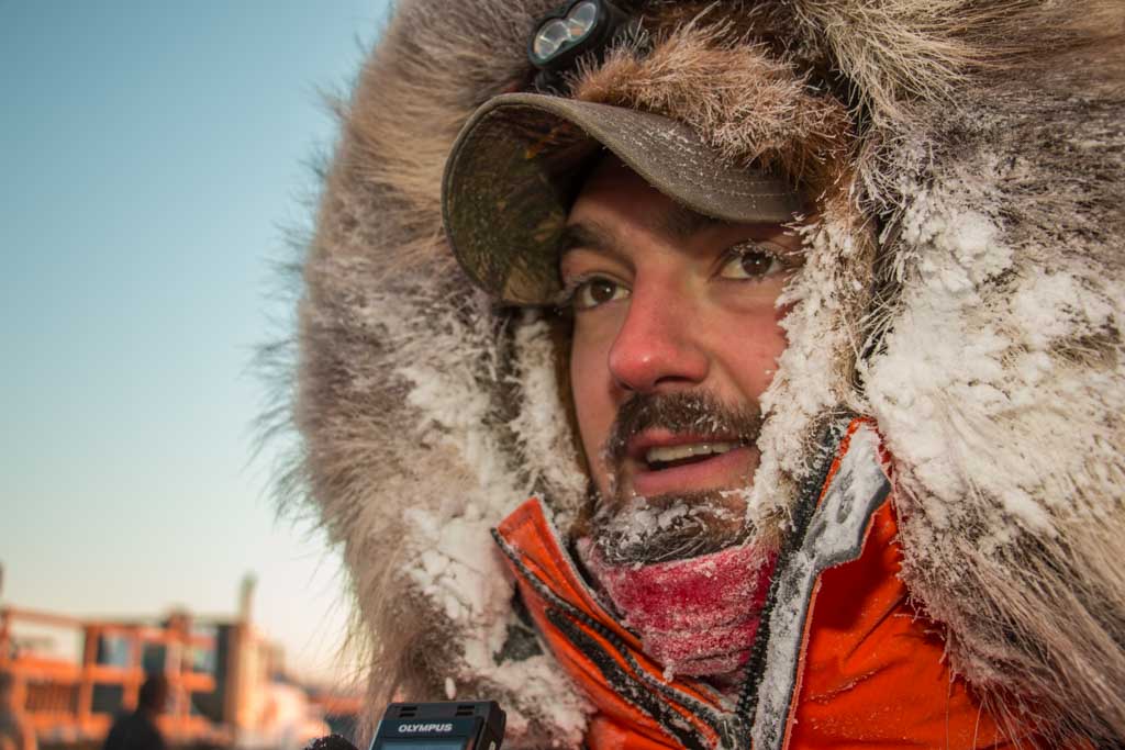 Pete Kaiser in an orange parka, moments after his 2017 Kuskokwim 300 victory