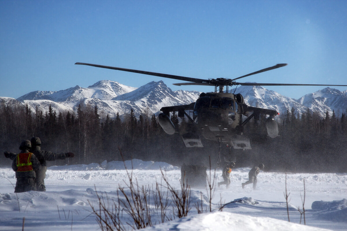 Soldiers clear the landing zone after cargo is secured to a UH-60 Blackhawk helicopter.