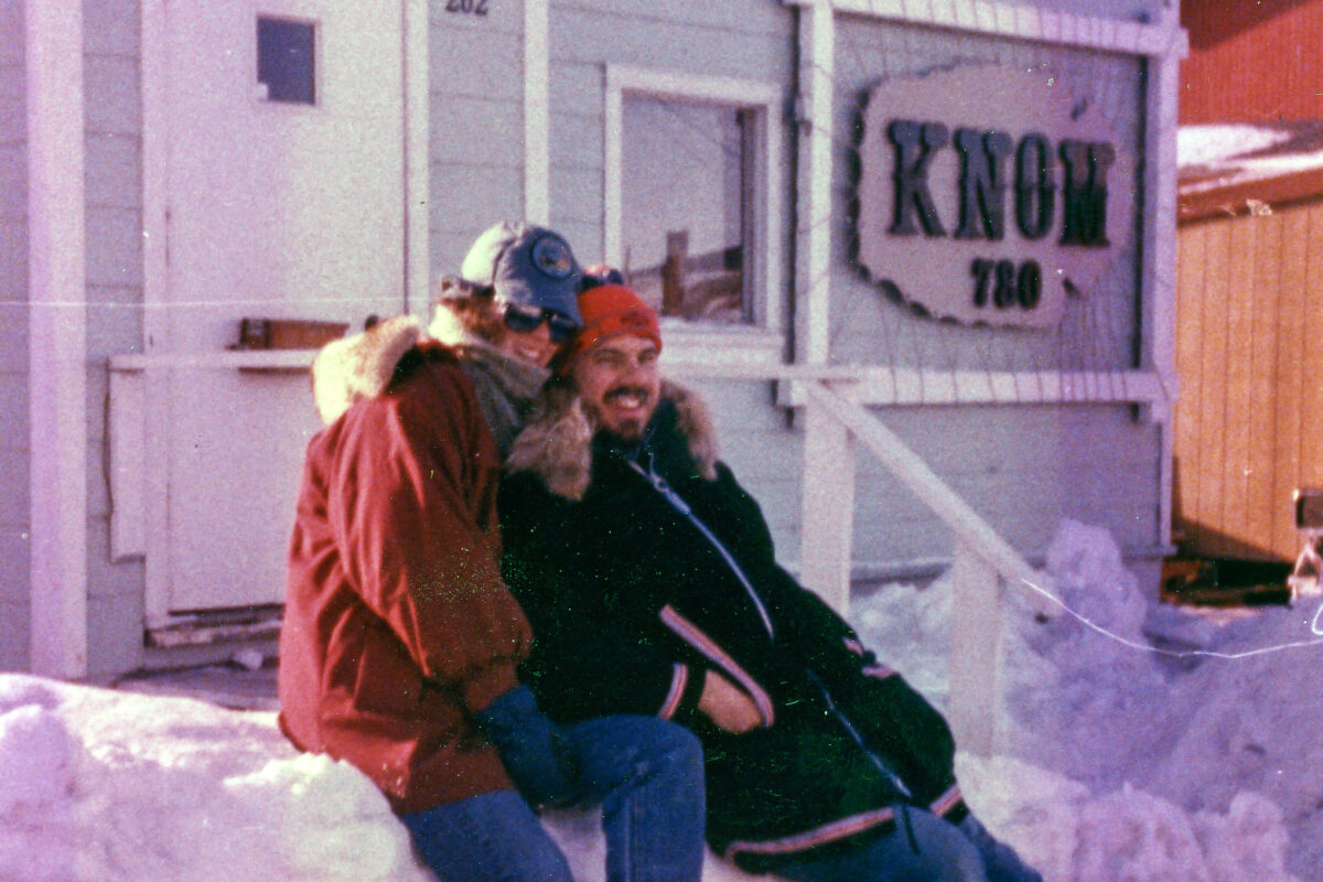 In their volunteer days (circa 1980s), Lynette and Ric Schmidt smile outside the old KNOM station building.