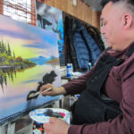 Don Henry adds foliage to his painting