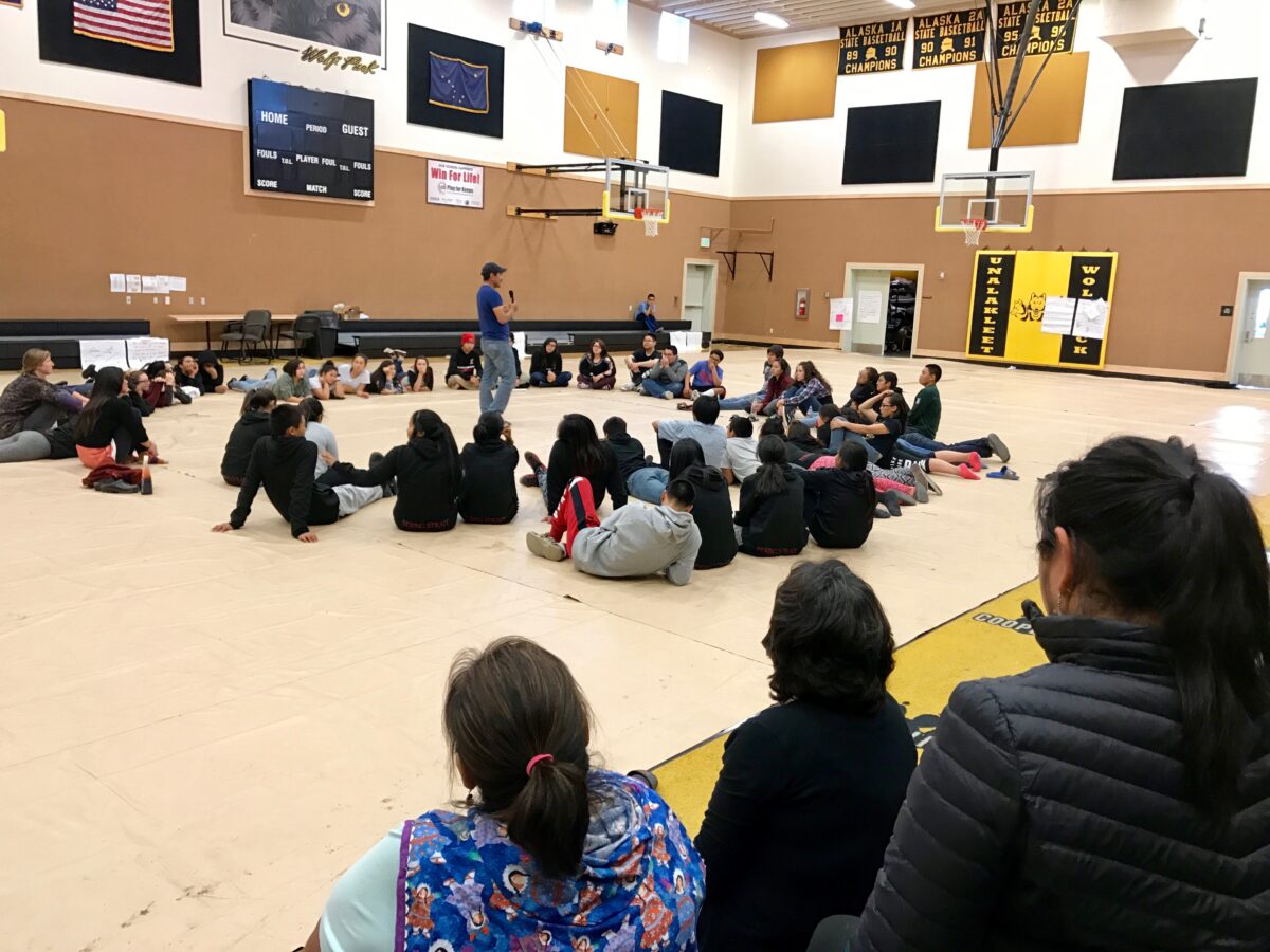 Students at the 2017 BSSD Youth Leaders retreat sit in a circle on the floor of the Unalakleet school gym to tell stories.