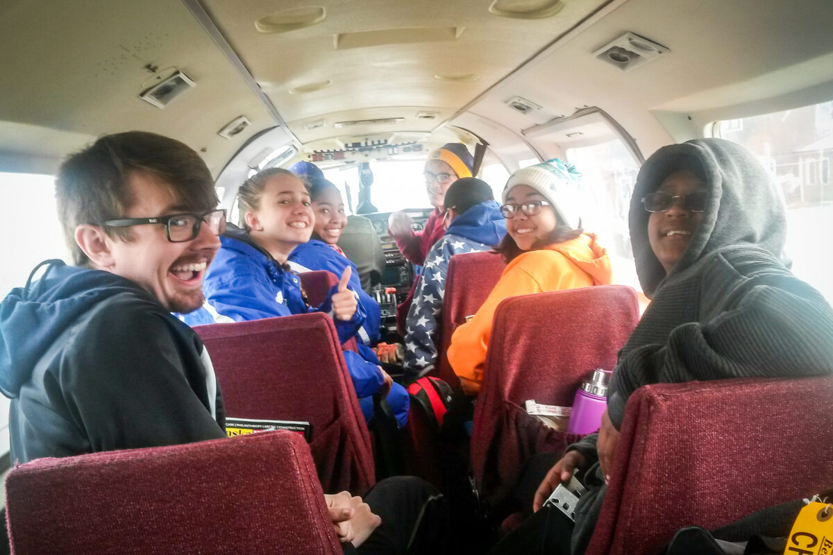 Teenage athletes inside a small airplane