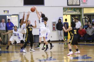 Nome girls, in white, fight with Unalakleet girls, in brown, fight to recover the basketball