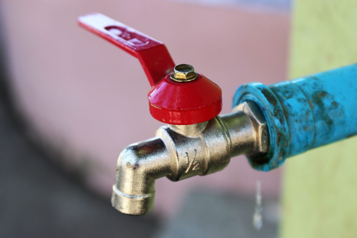 Exterior metal water spigot with red handle