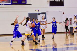 Three Nome girls, in purple, block a Kotzebue girl, in white, who tries to pass the ball