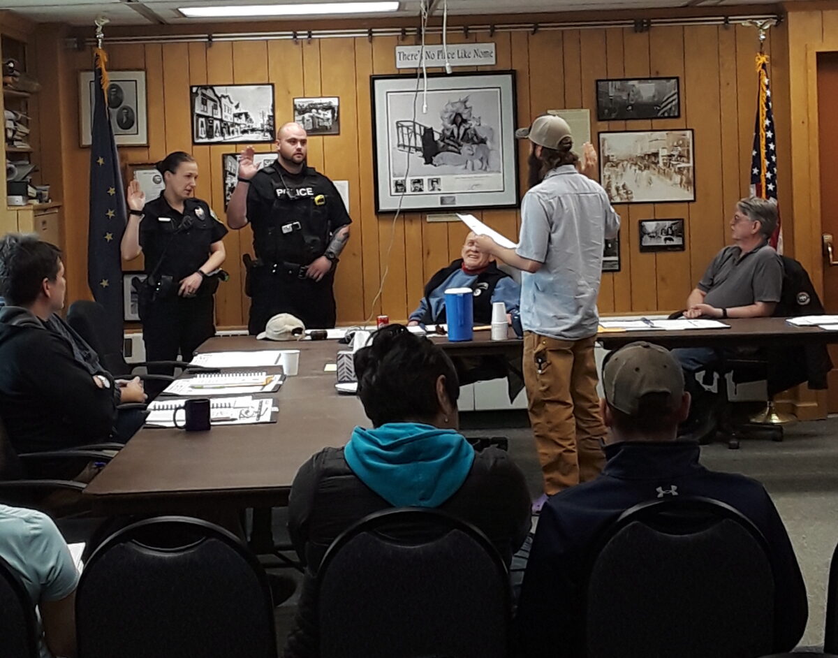 Two NPD officers take their oaths of office, led by City Clerk Bryant Hammond, during a regular City Council meeting. Photo Credit: Davis Hovey, KNOM (2018)