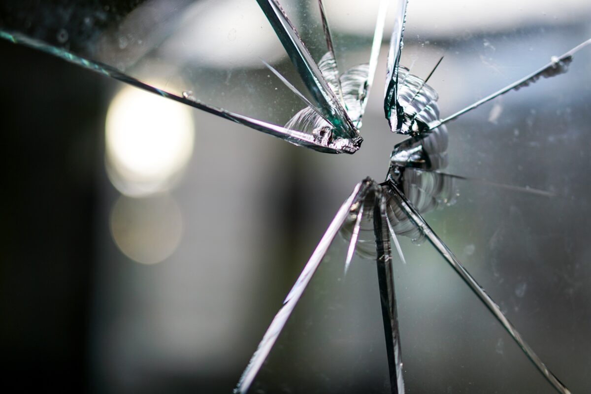 Close-up view of a broken glass window.