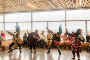 Alaska Native dance ensemble, mid-performance, next to a window overlooking Nome, Alaska.