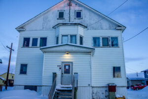 Exterior of off-white building in Nome at dawn.