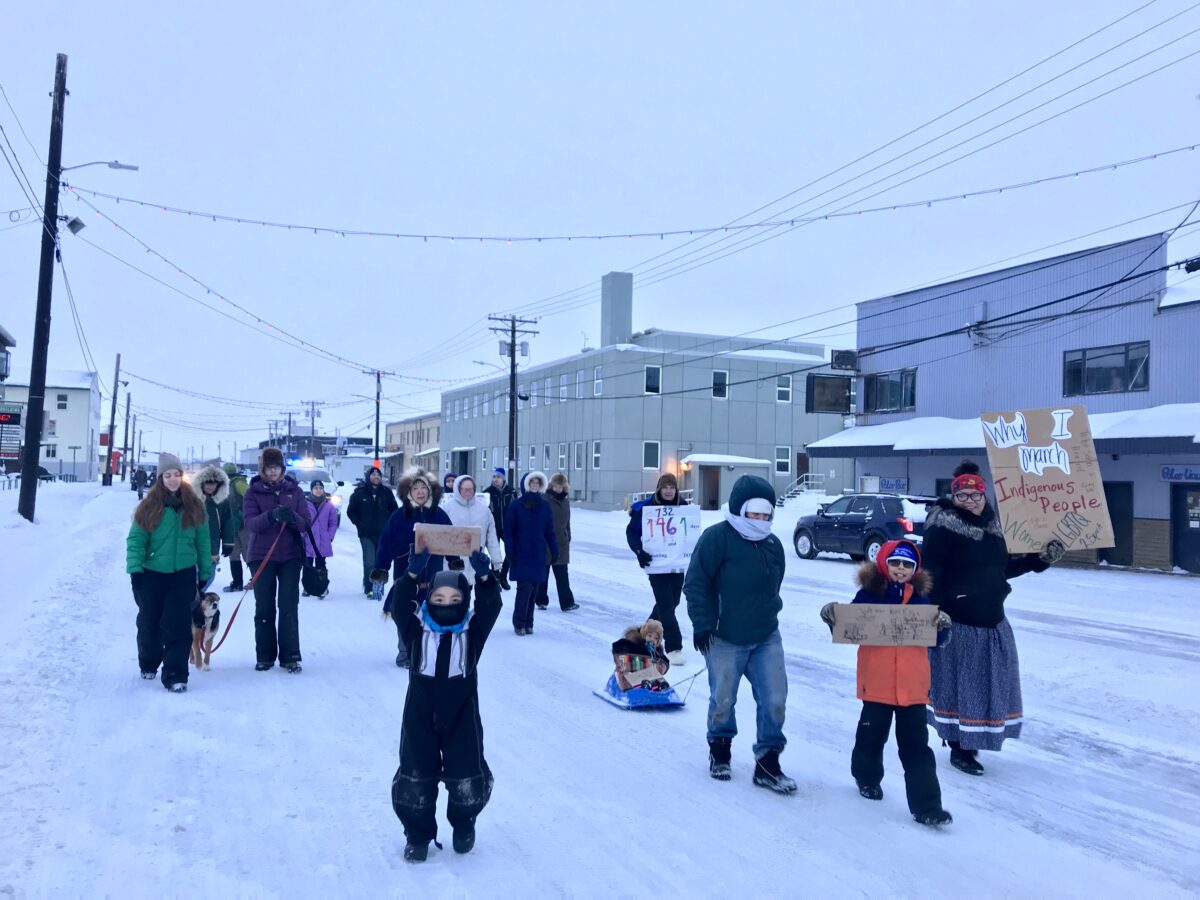 Group of marchers walks down Nome’s Front Street on a snowy winter day.