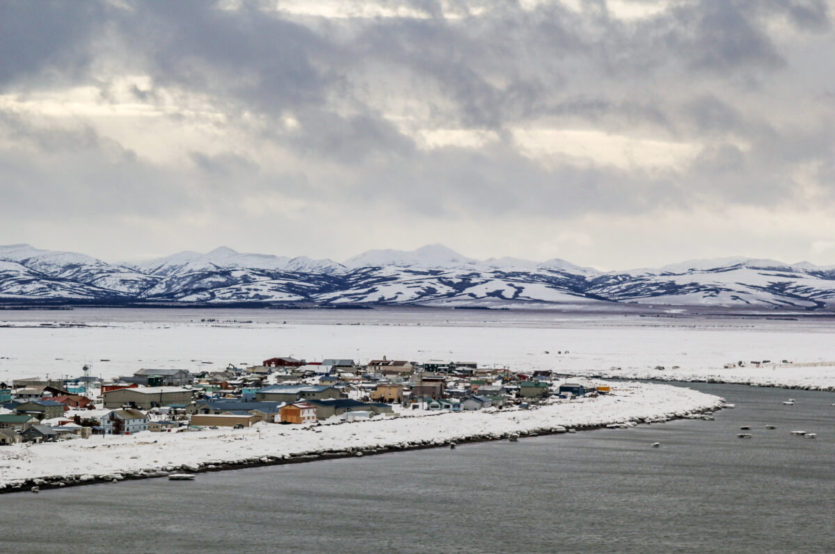 Aerial view of Unalakleet during winter, with open water along the coast.