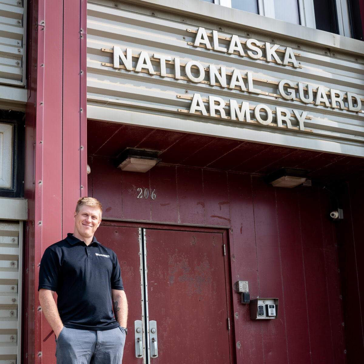 Man in black polo shirt stands outside the Alaska National Guard Armory in Nome