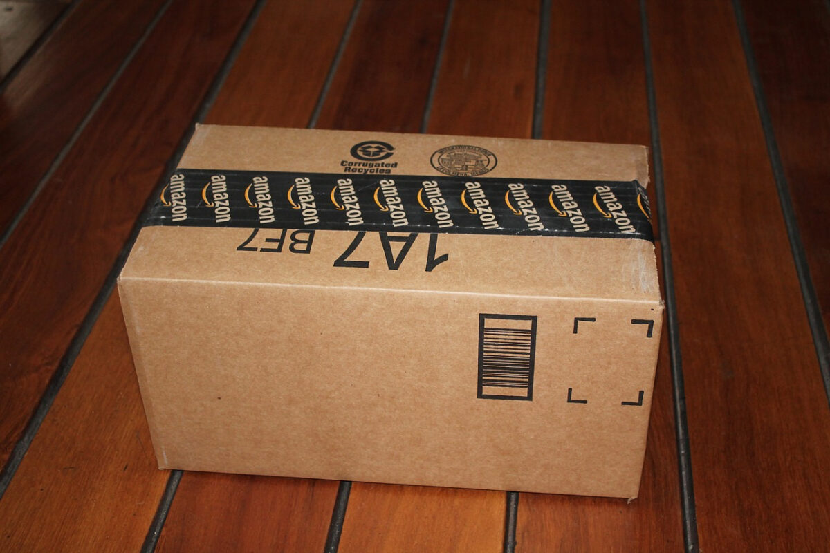 Cardboard package with Amazon branding on a hardwood floor