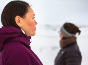 Profile shot of two woman standing outside in the winter time.