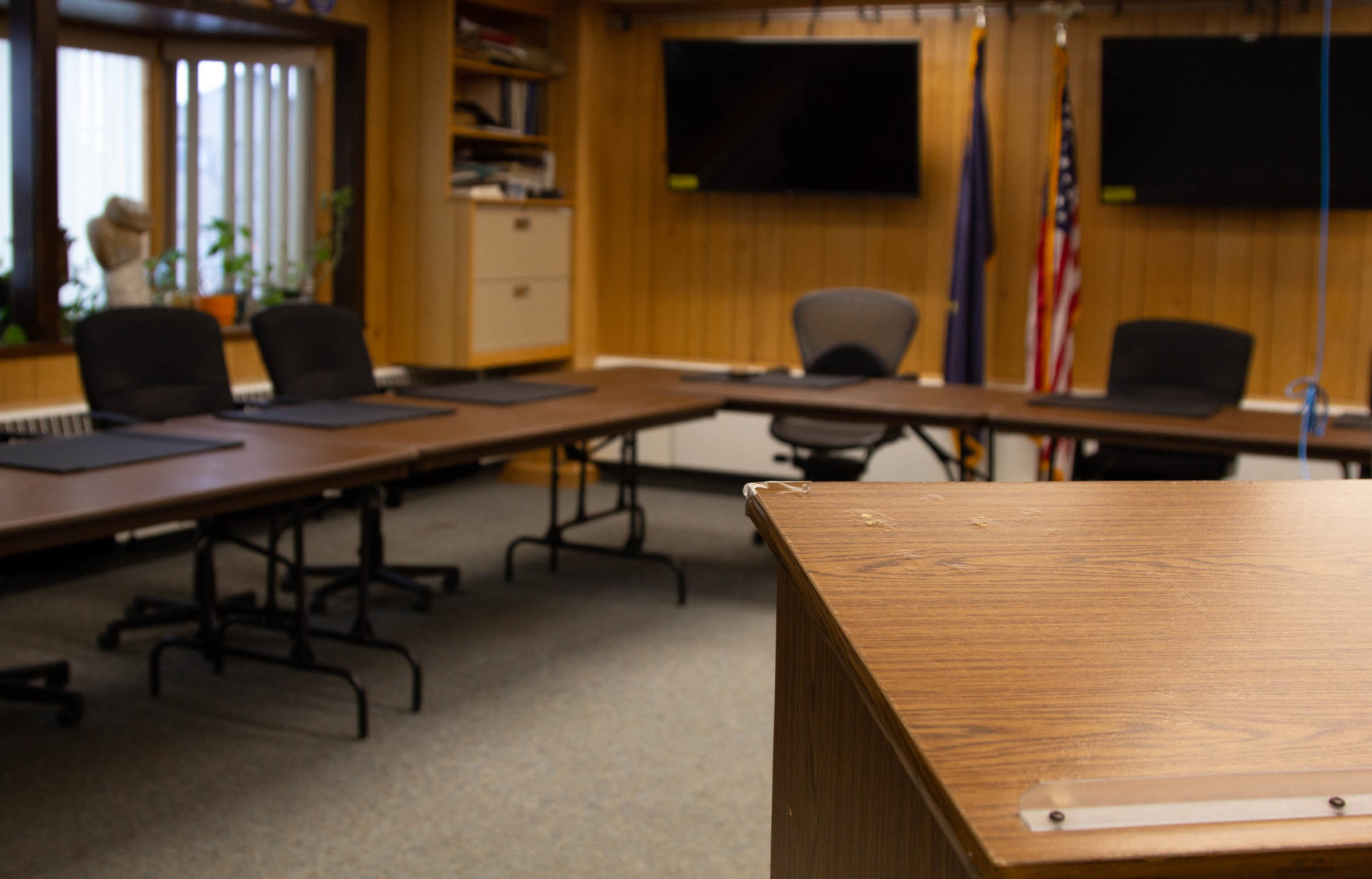 Cirty of Nome council chambers room. View from podium looking towards empty tables with chairs.
