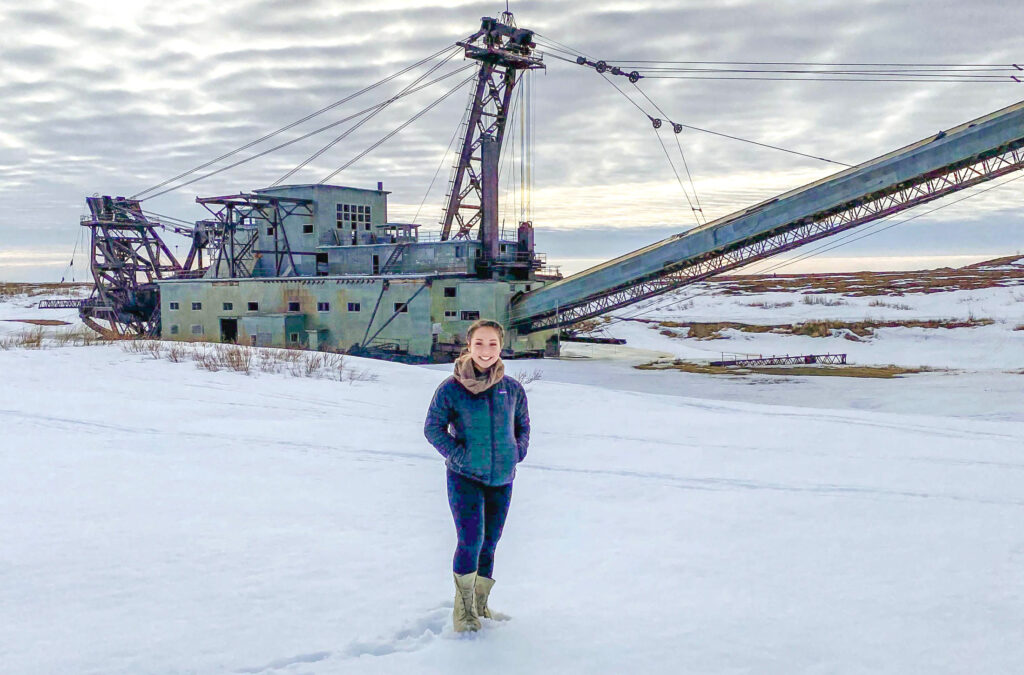 Katie Smith standing in front of a dredge in winter