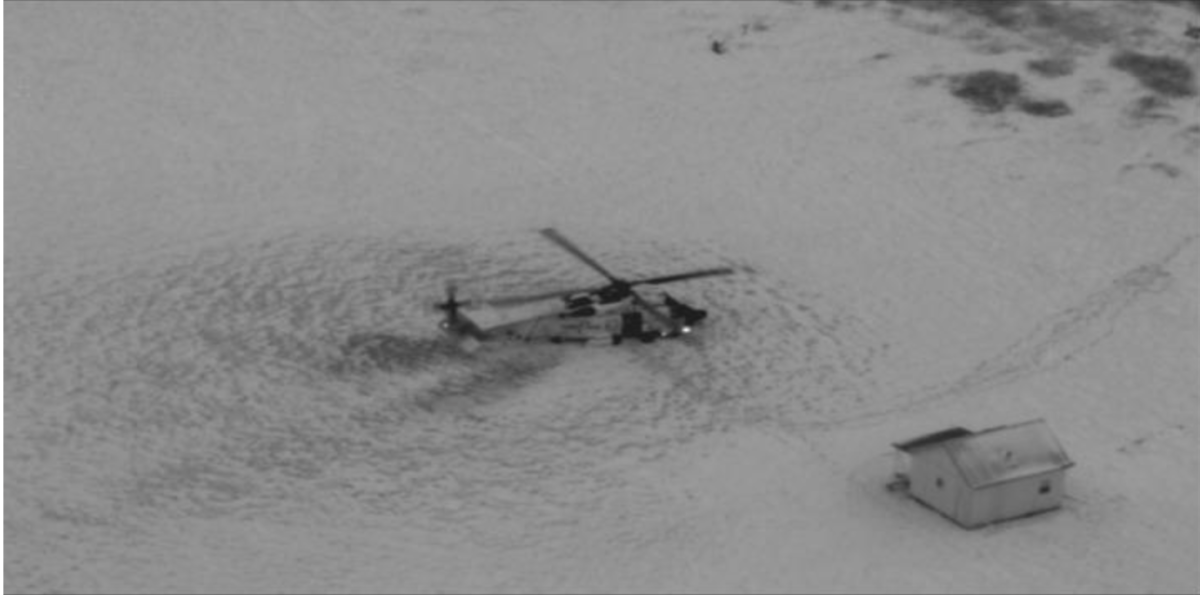 Black and white image of helicopter on the ground.