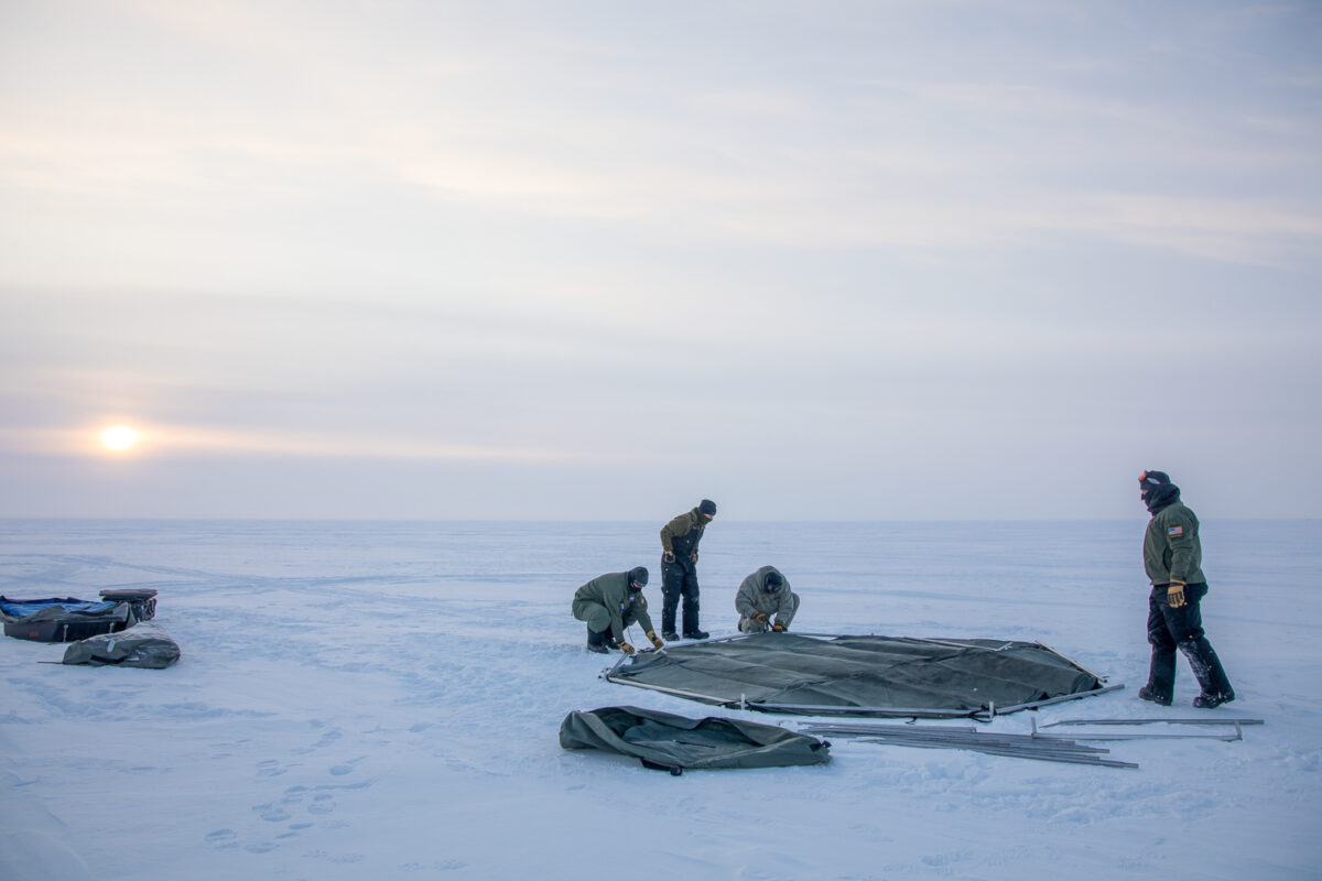 3 men building a shelter on the sea ice in Nome