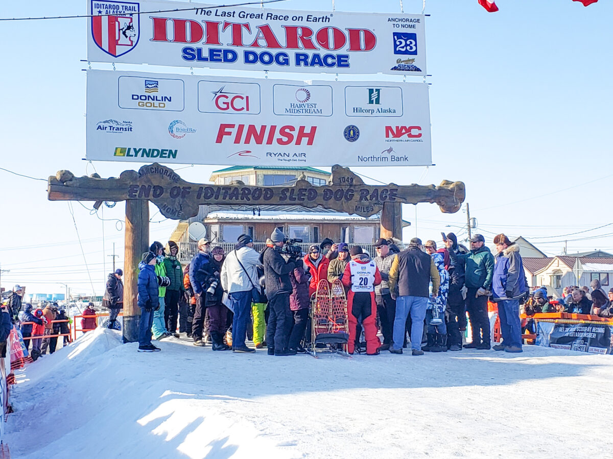 The Iditarod 2023 wrapped up on March 17th in Nome with Jason Mackey under burled arch as the red lantern with Greg Knight reporting (Photo from Davis with KNOM 2023).