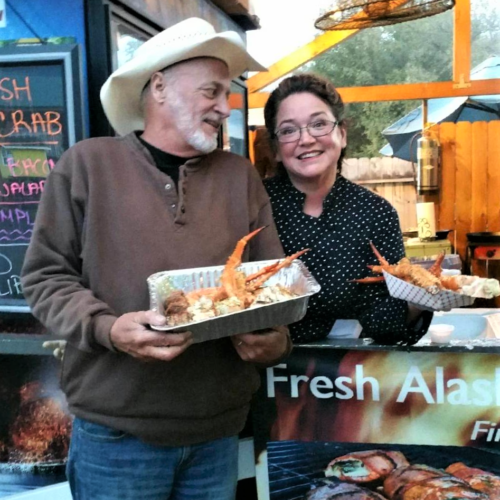 Meyer (left) shows off a seafood dish with singer-songwriter Hobo Jim. Photo courtesy Buffy Meyer