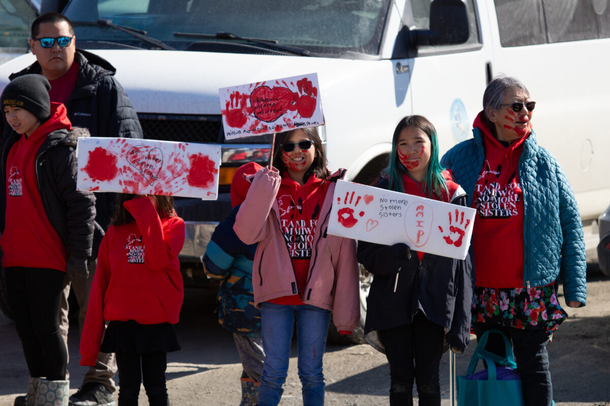 Young attendees hold signs marked with "No more stolen sisters" and red handprints. Ben Townsend photo.