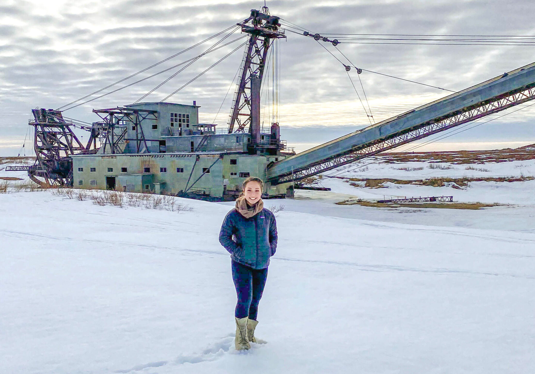 Katie Smith standing in front of a dredge in winter